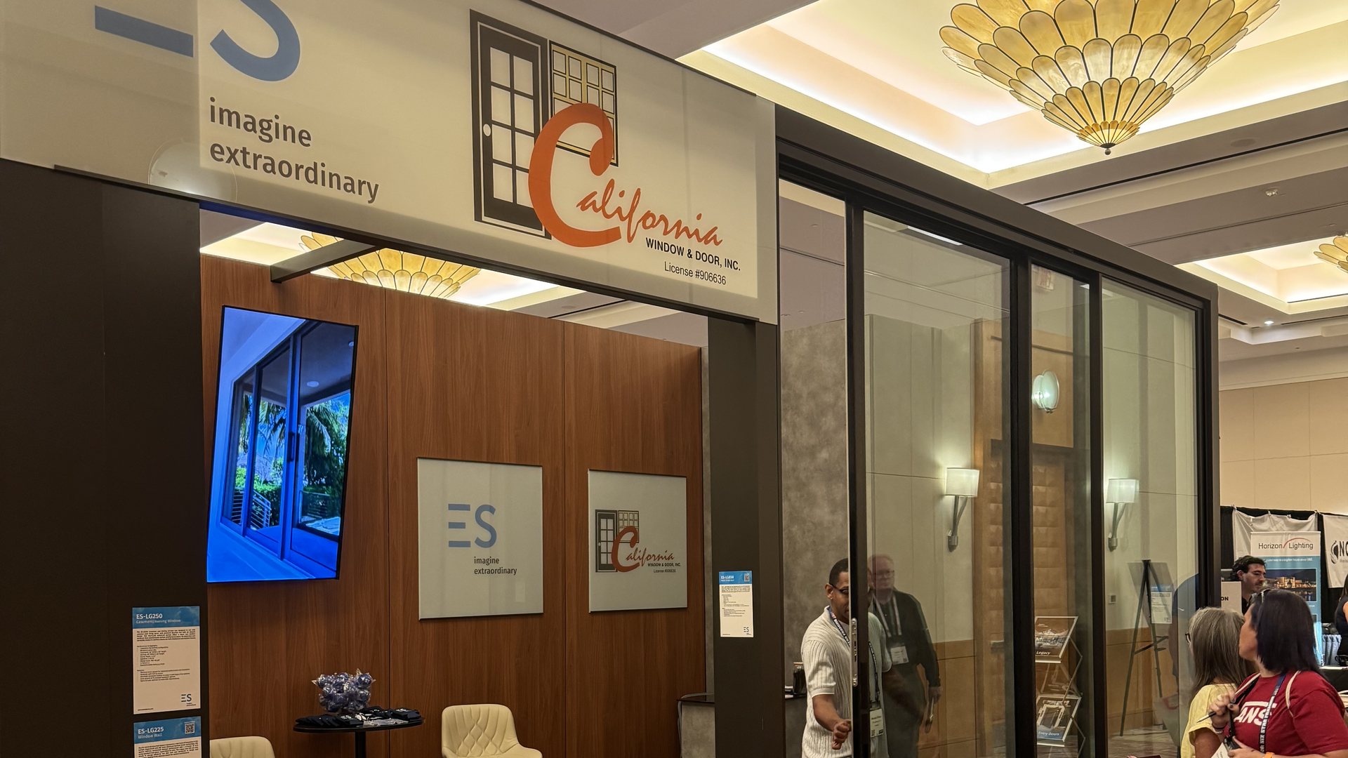 The joint ES Windows and California Window and Door booth at the Building Industry Show in Indian Wells, with the booth signage above an ES multi-slide glass door